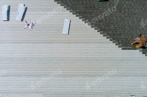 Preview: Worker nailed new roof shingles bitumen using air hammer an aerial view