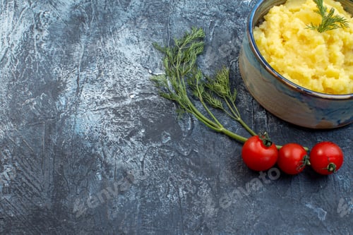 Preview: Half shot of mashed potatoes served with dill wooden spoon fresh tomatoes on dark color background
