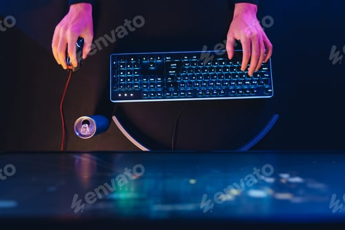 Preview: Pro gamer's hands on professional gaming keyboard and computer mouse in neon colour