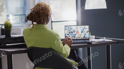 Preview: Executive assistant talking on remote video call at desk