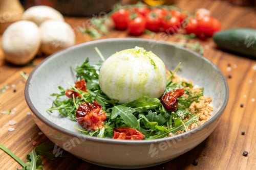 Preview: Gourmet burrata salad served in a rustic gray bowl. The creamy burrata sits