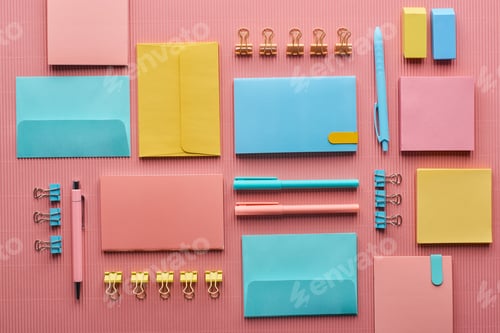 Preview: flat lay of colorful stationery supplies on pink