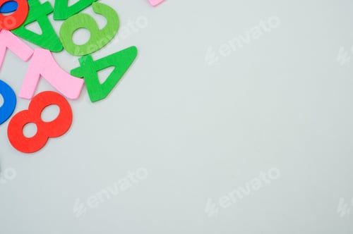 Preview: Closeup shot of the colorful wooden numbers scattered on a gray surface - space for text