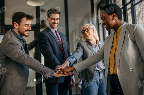 Preview: Business team joining hands showing unity and cooperation in office