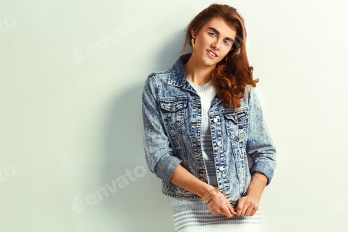 Preview: beautiful young blonde woman in nice dress and jeans jacket posing on white background in a studio.