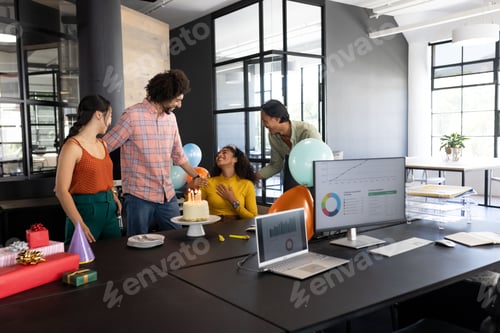 Preview: Celebrating birthday at office, colleagues smiling and presenting cake with candles