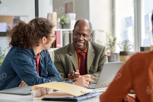 Preview: Smiling Senior Businessman Talking to Young Coworker