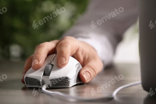 Preview: Woman using computer mouse with laptop at table, closeup