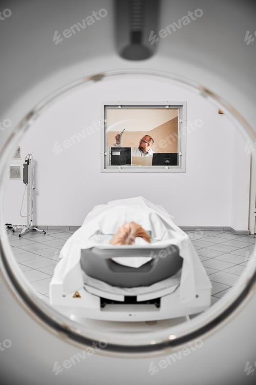 Preview: Blonde female patient lying on coach, making MRI.