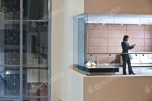 Preview: A view looking into a converence room at night with an Asian businesswoman at work.