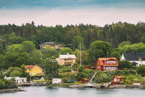 Preview: Sweden. Beautiful Red And Yellow Swedish Wooden Log Cabins Houses On Rocky Island Coast In Summer