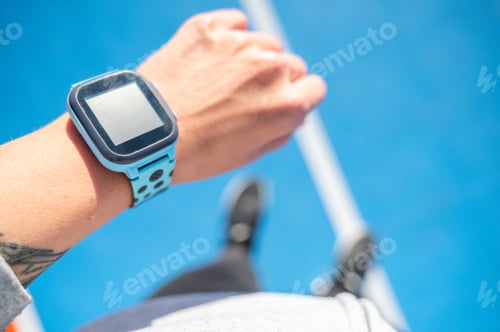 Preview: Hand with smartwatch monitoring activity on sports stadium
