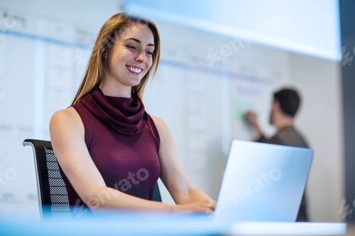 Preview: Young woman working in office with a colleague