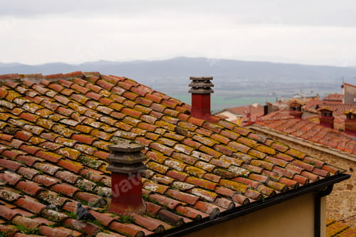 Preview: Weathered rooftop with chimneys and distant hills