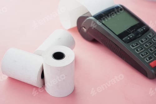 Preview: POS machine and long roll paper on blue .