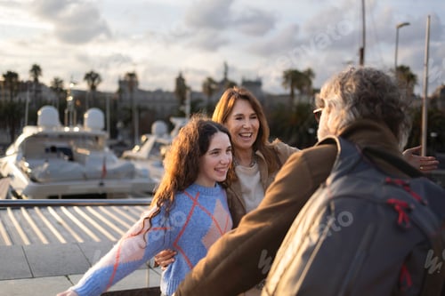 Preview: Happy family embracing at the barcelona marina during sunset