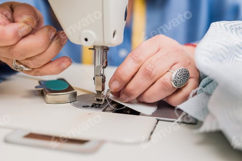 Preview: Atelier process needle detail. Unrecognizable woman hand on a sewing machine doing handmade fabric