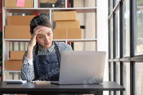 Preview: Teenager asian girl freelancer small business serious working at home office with laptop packaging