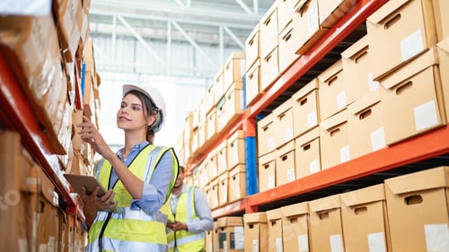 Preview: A worker in the warehouse uses a smart tablet to check the stock is on the shelves.