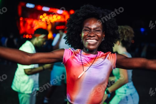 Preview: Joyful woman dancing at a vibrant night festival