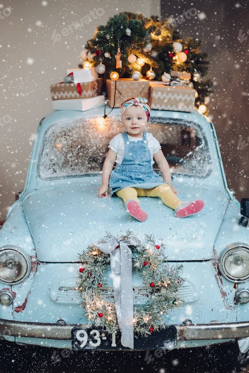 Preview: Front view of sweet and fashionable little cute girl sitting on blue retro car decorated for