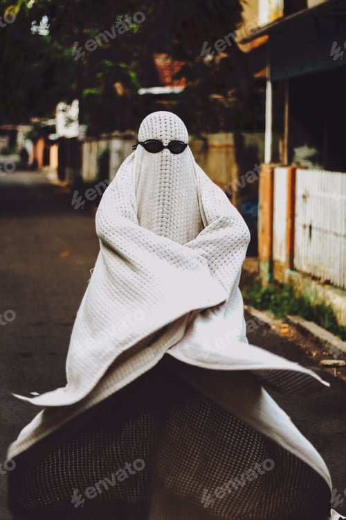 Preview: Vertical shot of human with black glasses in white ghost costume
