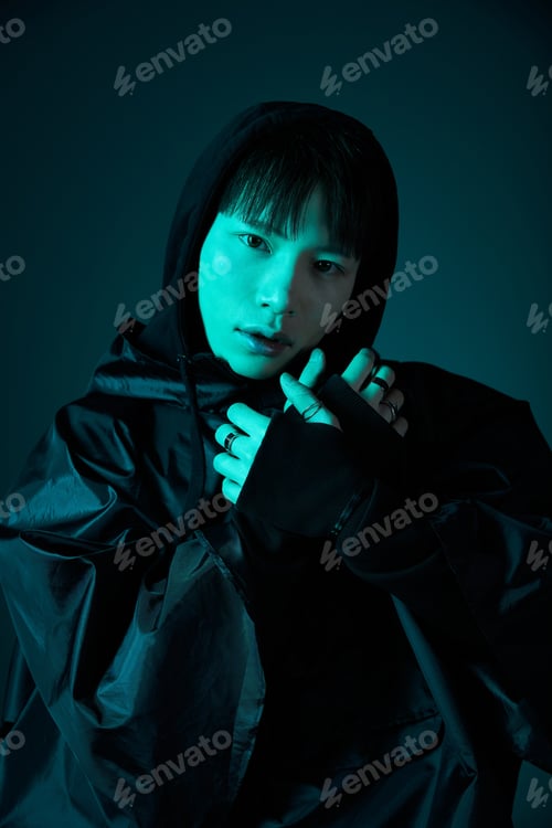 Preview: Stylish young man showcases modern fashion with an artistic flair in a dramatic lighting setup