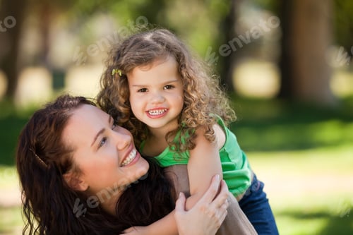 Vista previa: Mujer abrazando a su hija en el parque