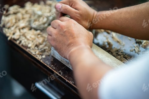Preview: man's hand woodworking with wooden dust
