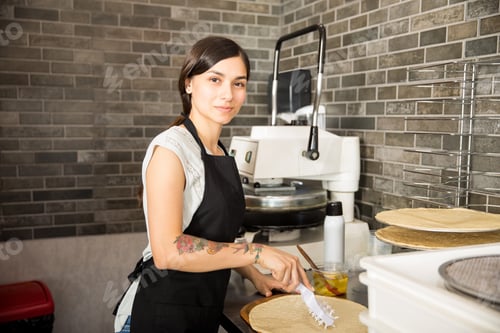 Preview: Beautiful young woman working in pizza shop with raw dough
