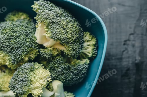 Preview: Raw broccoli over black wooden background. Healthy food, diet concept. Top view