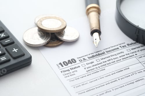 Preview: Close up of a Tax return form and pen on table.