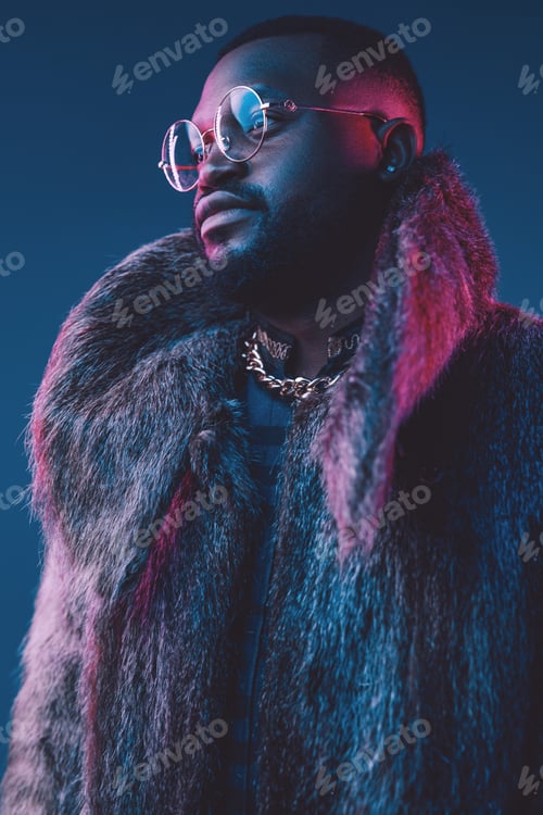 Preview: African man with fur coat and glasses against dark background