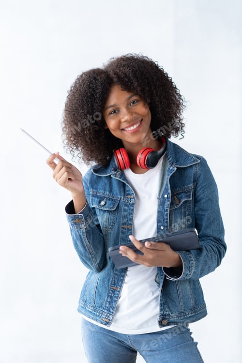 Preview: Focused young African female college student working on a laptop on living room.