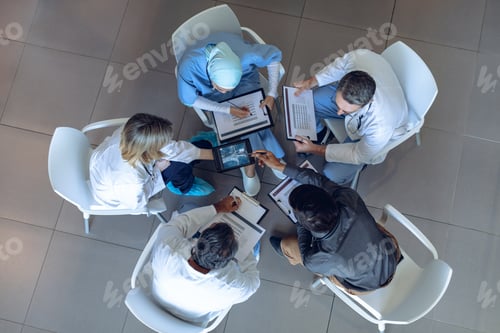 Preview: Diverse medical team discussing over digital tablet in hospital.