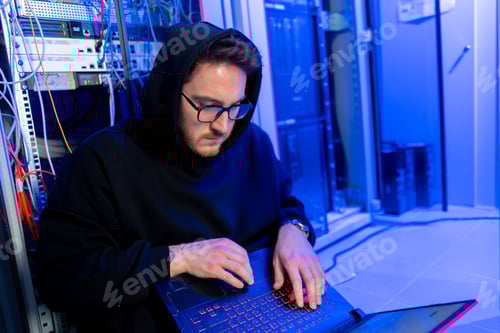 Preview: concentrated hooded hacker in data center hacking software system vulnerable cyber security server