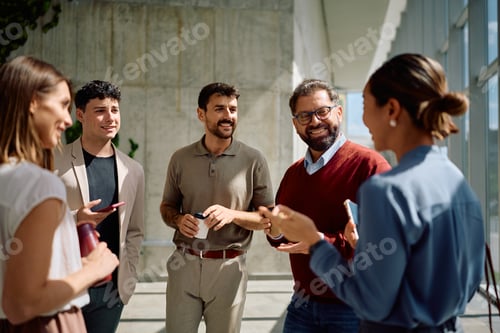 Preview: Multiracial group of coworkers communicating in office hallway.