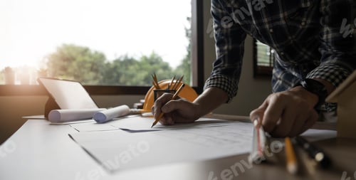 Preview: Concept architects, engineer holding pen pointing equipment architects On the desk with a blueprint
