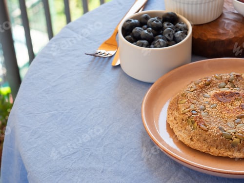 Preview: Table with blue napkin with served breakfast outdoors