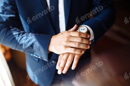 Preview: Stylish men's wrist watch, man is watching the time. . Businessman checking time on his wristwatch.