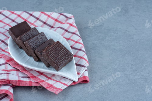 Preview: A bowl of chocolate coated on crispy wafer bar on the towel, on the marble background