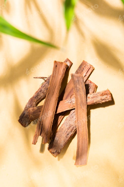 Preview: pile of bark of cat's claw medicinal plant, on yellow background top view