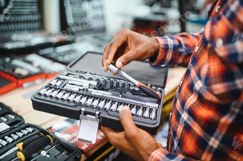 Preview: African american male buyer chooses a toolbox in a hardware store. A large selection of tools