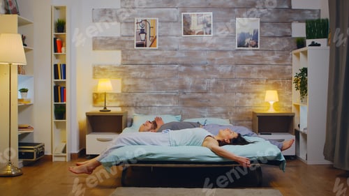 Preview: Married caucasian couple falling back on bed