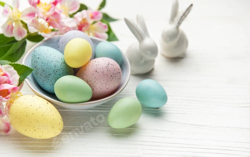 Preview: Pastel colored easter eggs in bowl with spring flowers and porcelain bunnies