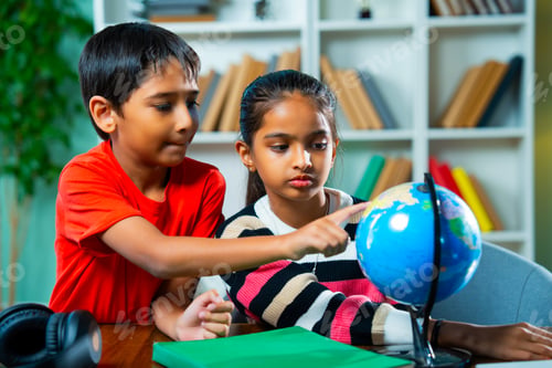 Preview: Indian Boy and Girl Siblings Playing with Educational Globe at Home – Geography Learning Concept