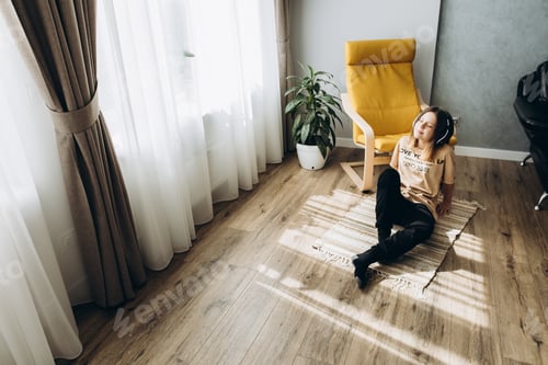 Preview: teenage girl with headphones sitting on the floor in the room