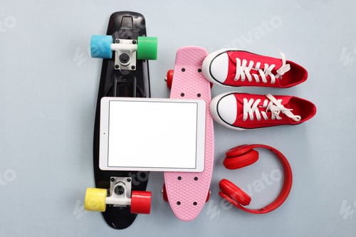 Preview: Modern tablet, headphones, skateboards and shoes on light grey background, flat lay. Space for text