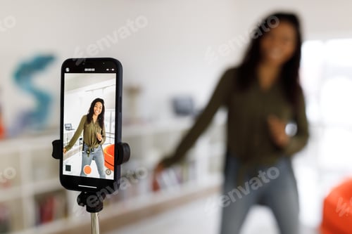 Preview: Cheerful black woman filming video on cellphone