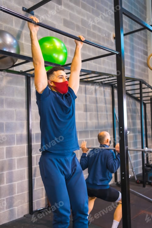 Preview: View of Two athletes performing strength exercises in the gym during the coronavirus pandemic
